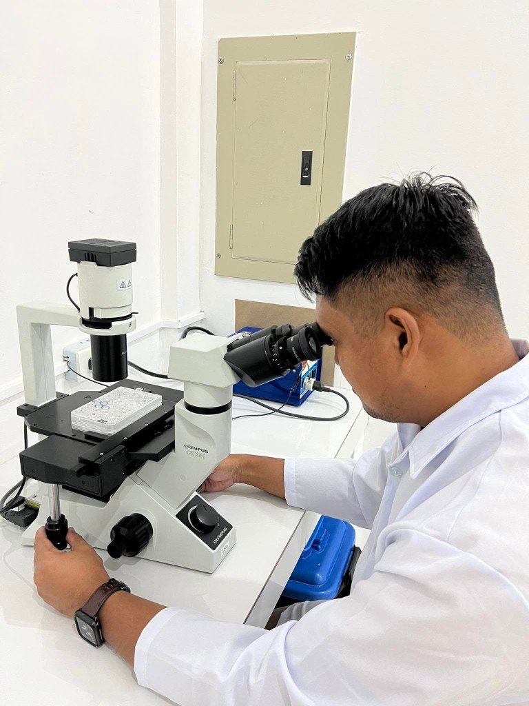 Researcher using a microscope at the CLSU-ADB Laboratory